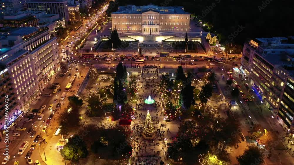 Aerial drone video of illuminated festive Syntagma square featuring Greek Parliament and Christmas tree, Athens centre, Attica, Greece