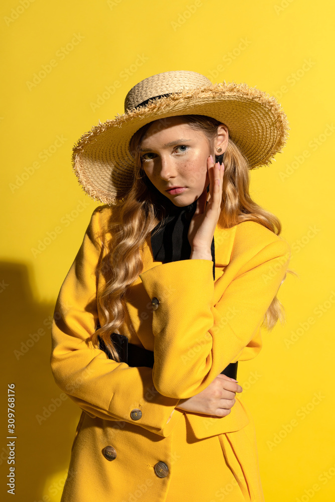 Pretty blonde girl with freckles in yellow outfit and straw hat Pretty blonde girl with freckles in yellow outfit and straw hat