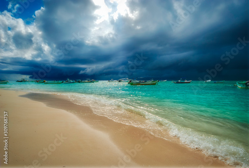 Fototapeta Naklejka Na Ścianę i Meble -  Storm and rain coming to the Caribbean sea of Playa del Carmen Mexico. Fishing boats anchored near the beach