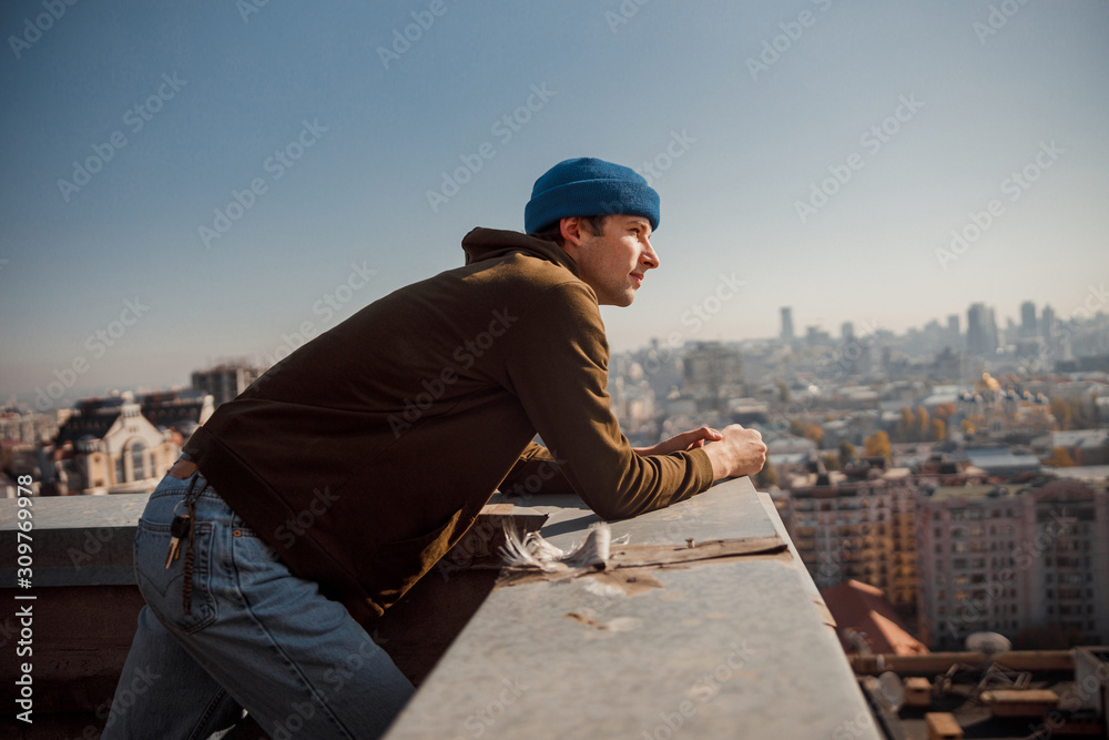 Happy guy enjoying the city view on roof
