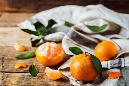 Tangerine fruit with slices, peel and leaves