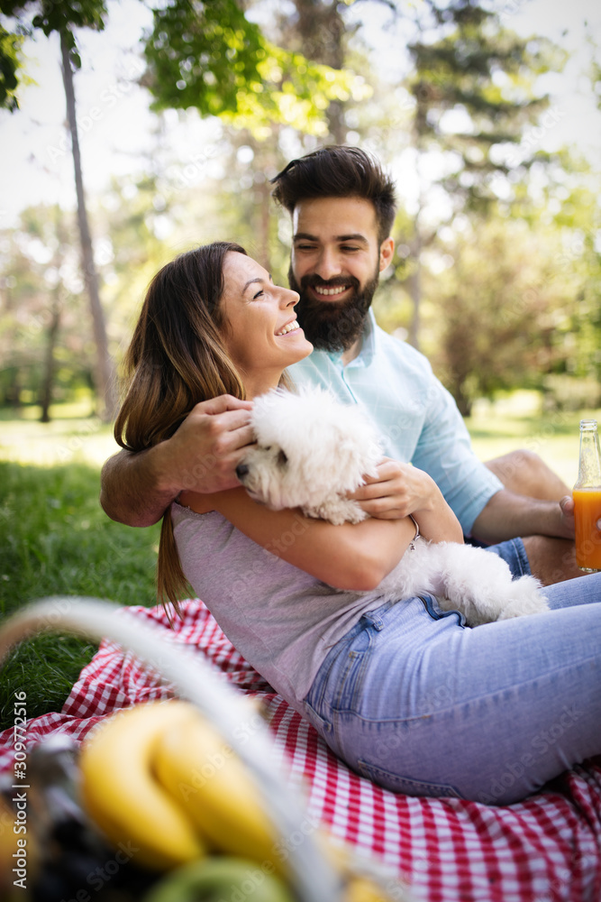 Lifestyle, happy couple resting at a picnic in the park with a dog Lifestyle, happy couple resting at a picnic in the park with a dog