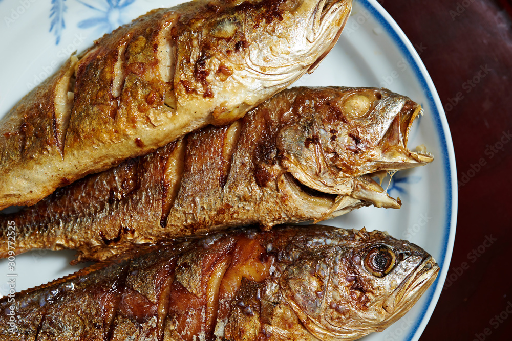 3 grilled fishes on white plate 3 grilled fishes on white plate