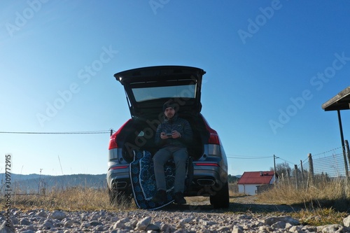 Aerial dronie selfie flying on mountains nature  young man pilot controlling dron with controller and smart phone photo