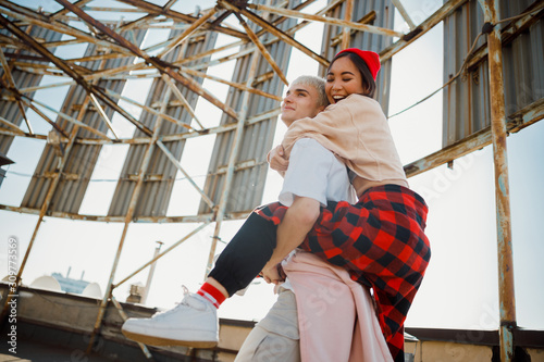 Happy pretty lady hugging her boyfriend on roof