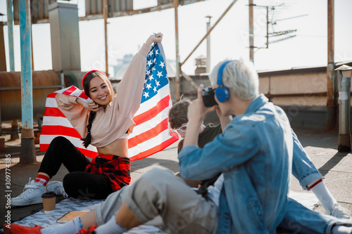 Happy Asian girl sitting with flag on the roof