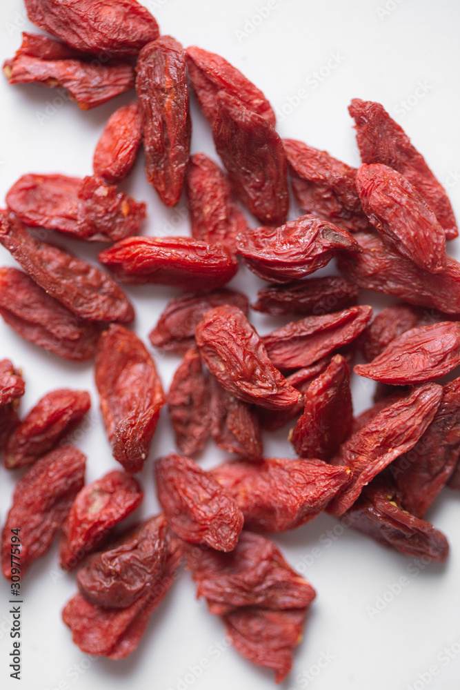 Red dried goji berries on white marble background