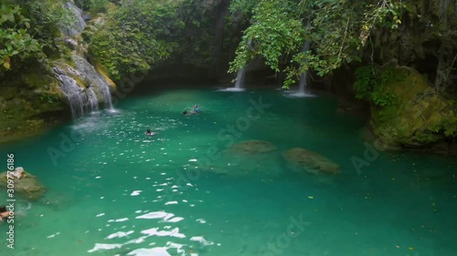 Kawasan Falls on Cebu Island, Philippines. People swimming at the natural pool of the waterfall photo