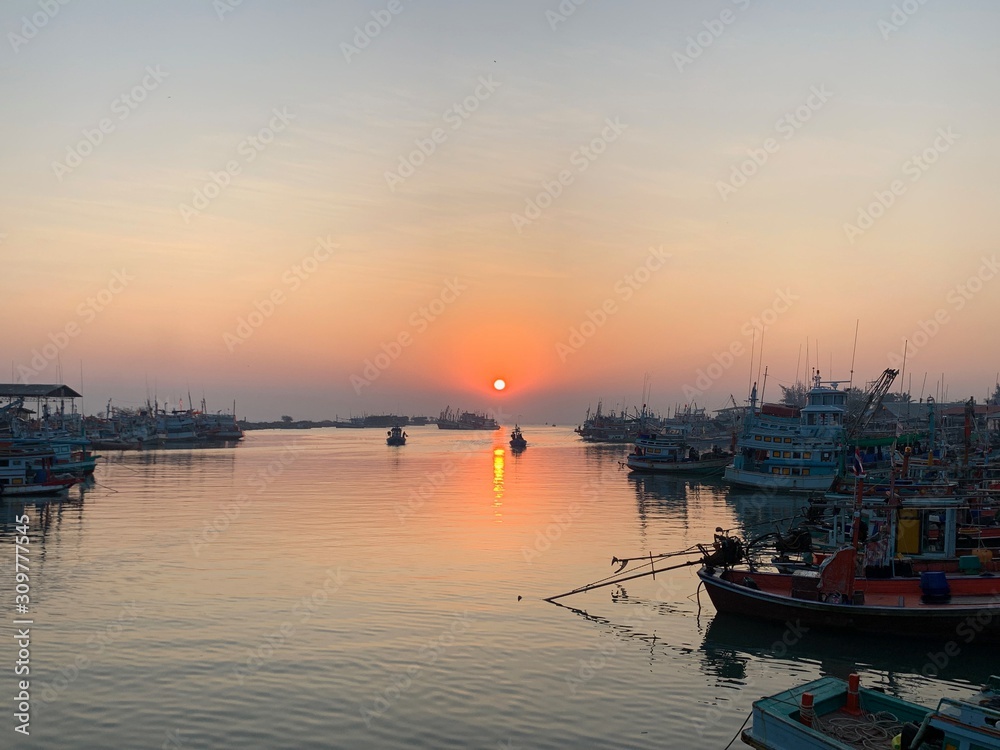 Sunrise scenery at sea With fishing boats parked along the coast