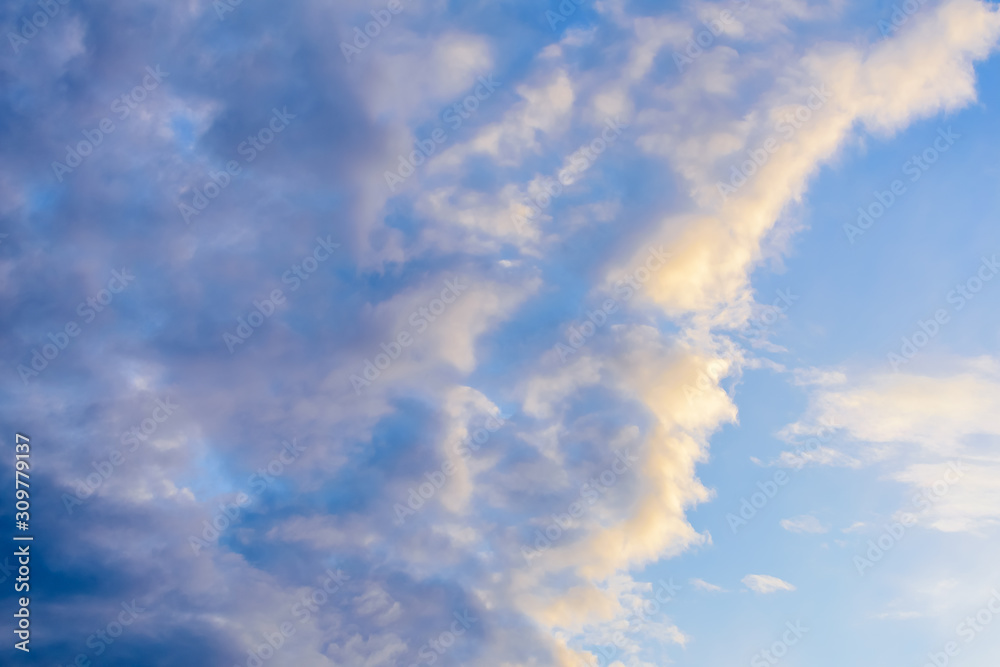 Beautiful puffy clouds at sunset isolated against pastel blue and pink skies Beautiful puffy clouds at sunset isolated against pastel blue and pink skies