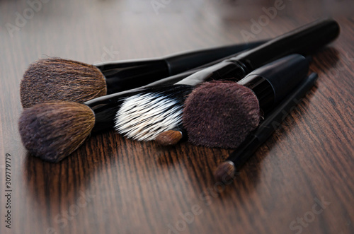 soft makeup brushes and maskara on black background