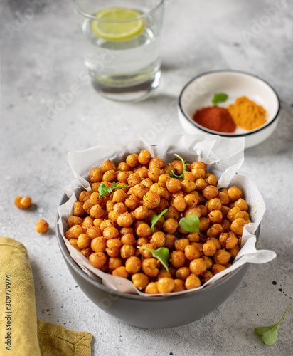 Roasted chickpeas with spices in bowl. healthy food concept. gray concrete background, vertical image