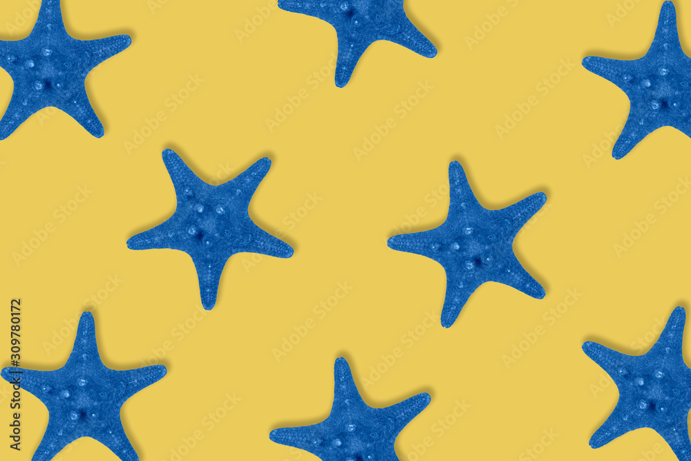 Dried toned in blue sea star fish pattern on yellow background.
