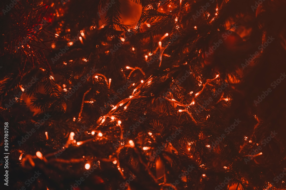 Fir tree branches with glowing red Christmas light as modern background, fashion color Fir tree branches with glowing red Christmas light as modern background, fashion color