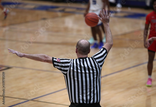 A basketball referee signals a foul