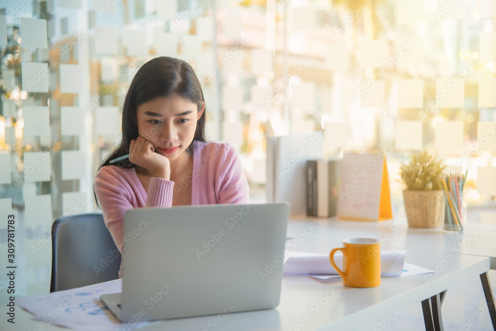 Portrait of pretty young woman using her laptop in the office. Portrait of pretty young woman using her laptop in the office.