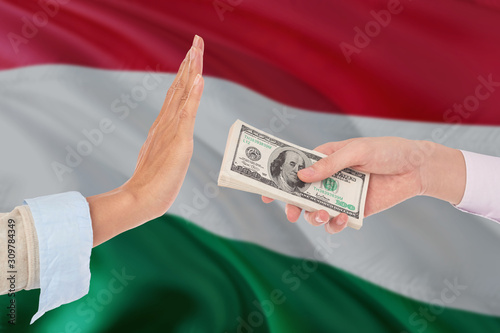 Hungary bribery refusing. Closeup of female hands extending a pile of dollar bills to the male hands gesturing as if rejecting the money.