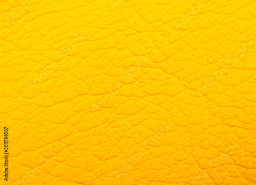 Extreme macro shot of bright yellow leather as a leather texture or an abstract yellow background