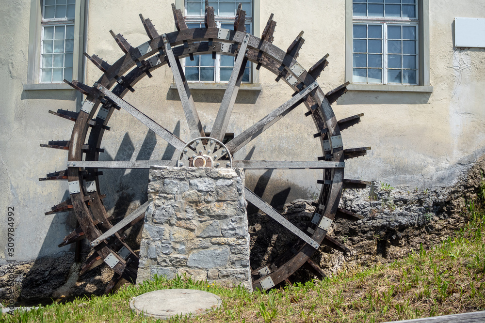 Wooden turbine beside the medieval europe style house , background , copy space Wooden turbine beside the medieval europe style house , background , copy space