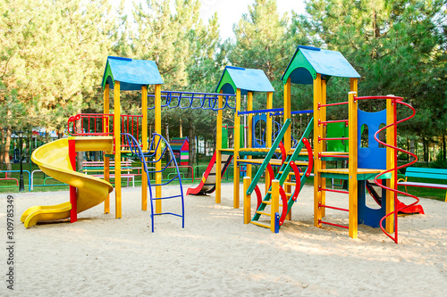 Colorful playground on yard in the park. Colorful children playground,exercise kid,activities in outdoor public park surrounded by green trees photo