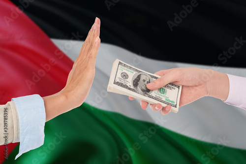 Palestine bribery refusing. Closeup of female hands extending a pile of dollar bills to the male hands gesturing as if rejecting the money.