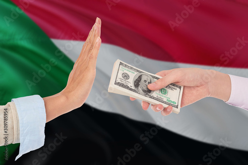 Sudan bribery refusing. Closeup of female hands extending a pile of dollar bills to the male hands gesturing as if rejecting the money.