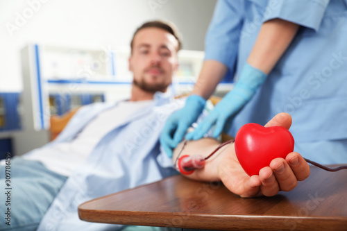 Obraz na plátne Young man making blood donation in hospital, focus on hand