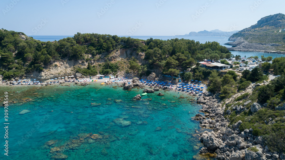 Aerial view of tropical island, white beach, turquoise lagoon, rocks and islands on horizon, Rhodes,Greece. Life in paradise. Travelling and holiday concept. 