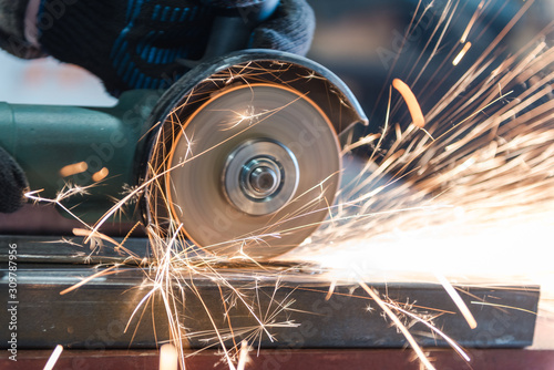 Cut metal with a Angular grinding machine. Sparks are flying. Construction tool grinder. A man is cutting metal. Wear gloves for safety.