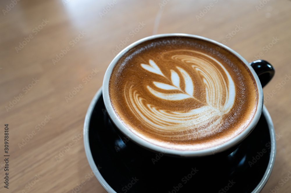 Close up of latte art coffee on wooden table Close up of latte art coffee on wooden table