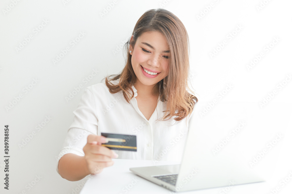Asian woman using credit card shopping online with laptop computer on white background Asian woman using credit card shopping online with laptop computer on white background