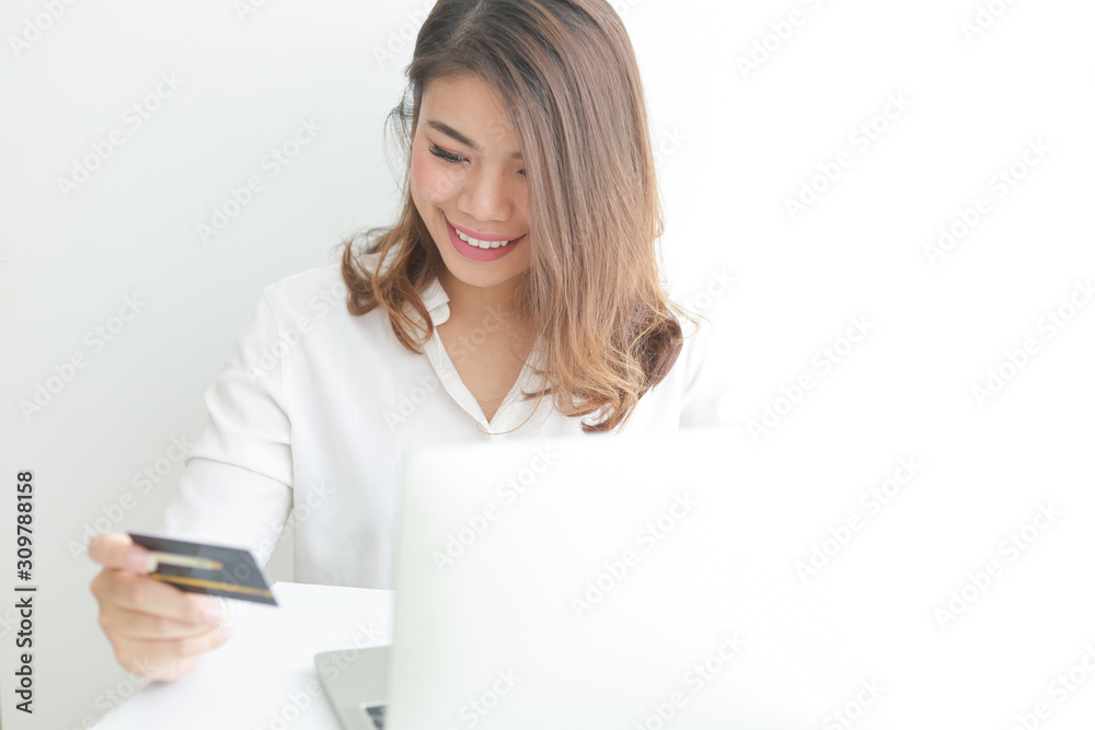 Asian woman using credit card shopping online with laptop computer on white background Asian woman using credit card shopping online with laptop computer on white background