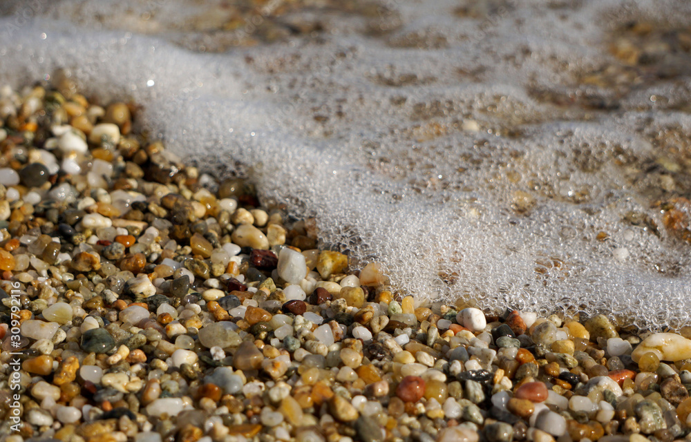 close up of a pebble beach when a wave came close up of a pebble beach when a wave came