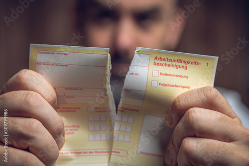 Arbeitsunfähigkeitsbescheinignung wird zerrissen photo