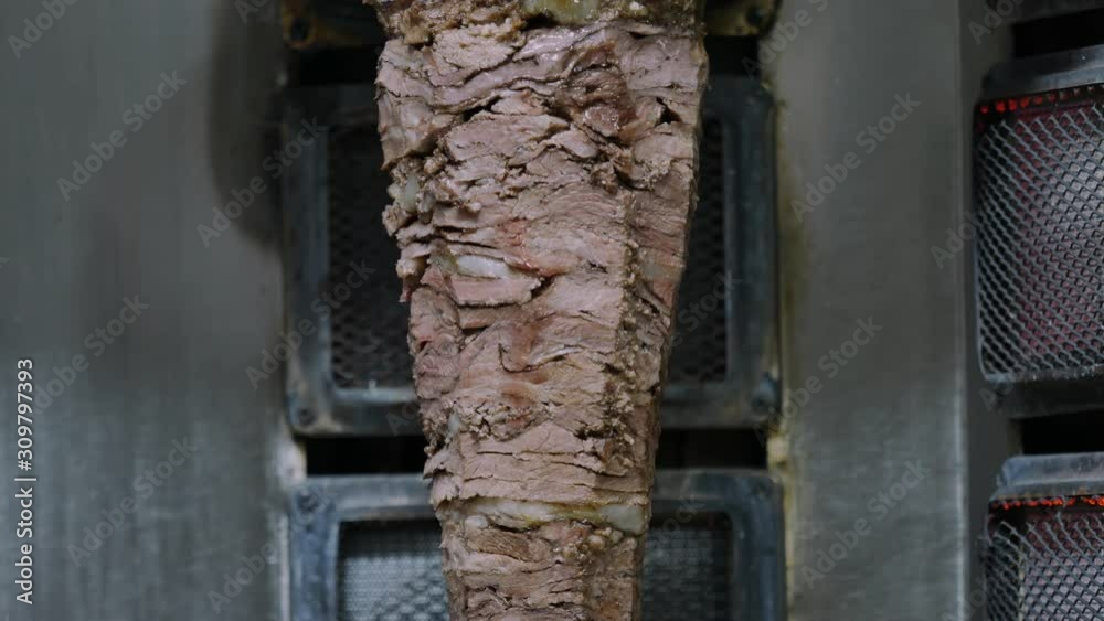 Machine for cooking shawarma, meat layers strung on a skewer. Street food . Machine for cooking shawarma, meat layers strung on a skewer. Street food .