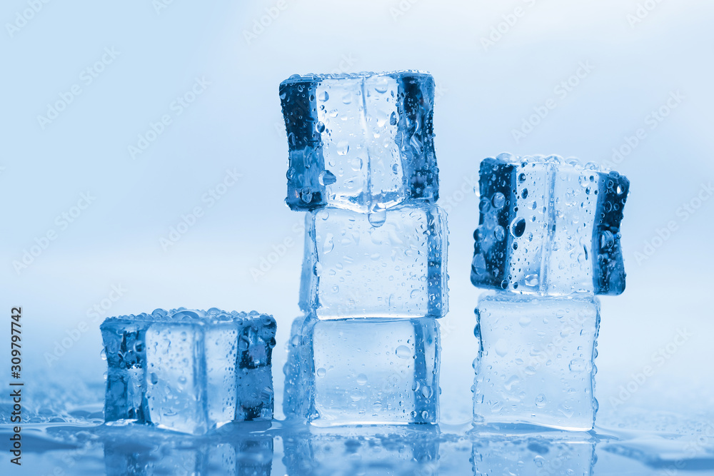 Ice cubes square with drops water clean on blue background Ice cubes square with drops water clean on blue background
