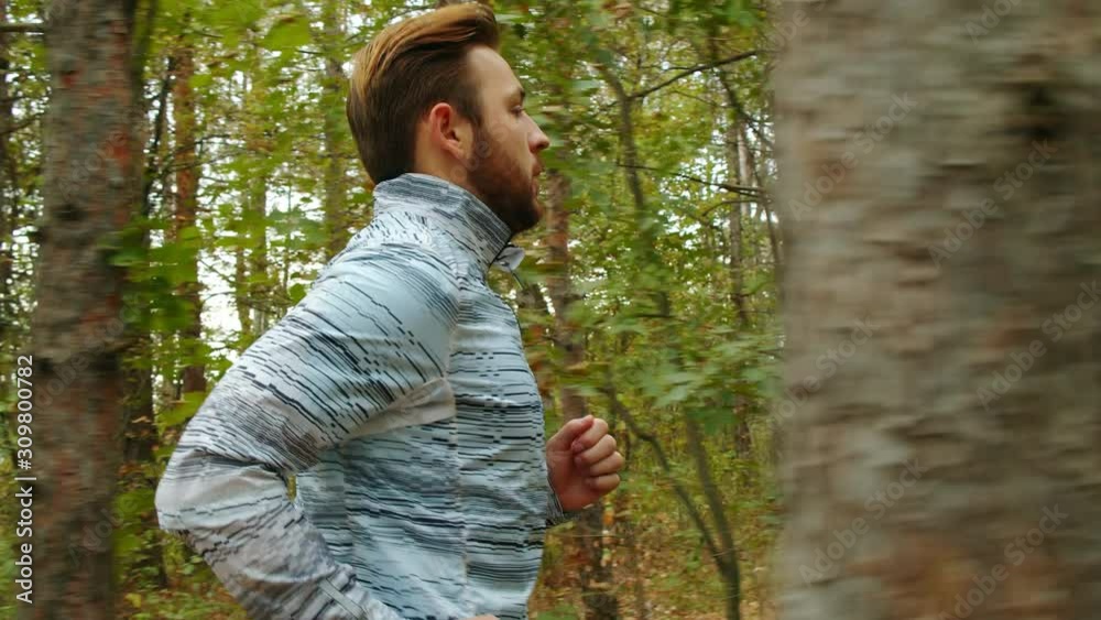 Tracking camera of a young man running jogging in autumn park, wood, forest, 4k slow motion Tracking camera of a young man running jogging in autumn park, wood, forest, 4k slow motion
