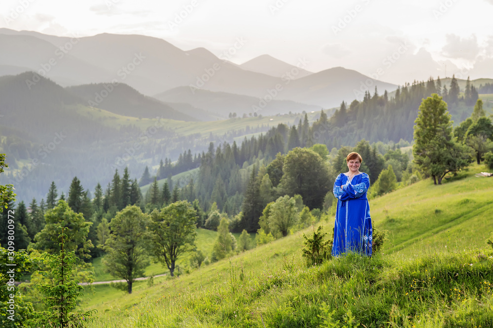 Charming woman at sunset in the mountains