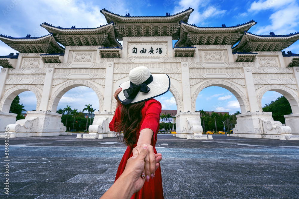Women tourists holding man's hand and leading him to Chiang Kai Shek Memorial Hall in Taipei, Taiwan.