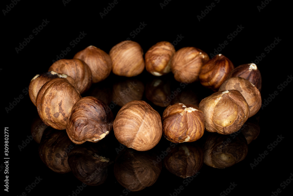 Lot of whole tasty brown hazelnut circle isolated on black glass Lot of whole tasty brown hazelnut circle isolated on black glass