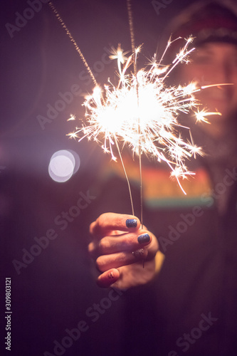 Happy girl is holding a sparkler at new year