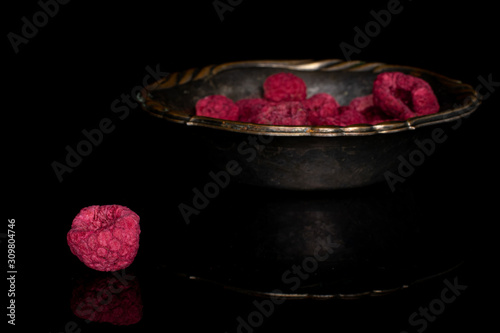 Tableau sur toile Lot of whole dried raspberry in copper bowl isolated on black glass