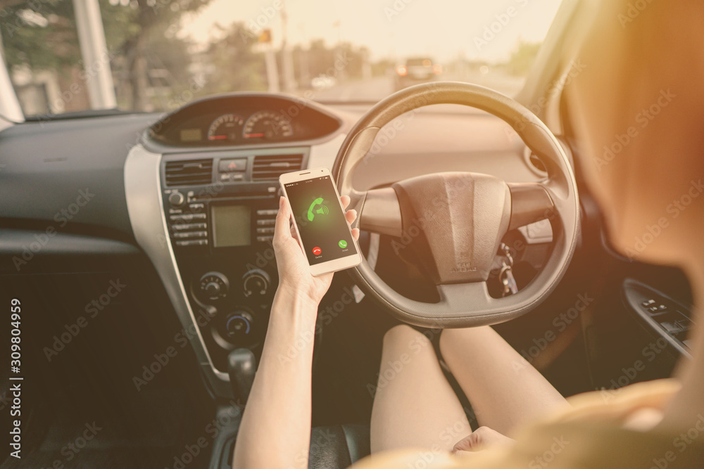 Close-up of woman talking on mobile phone while driving a car.