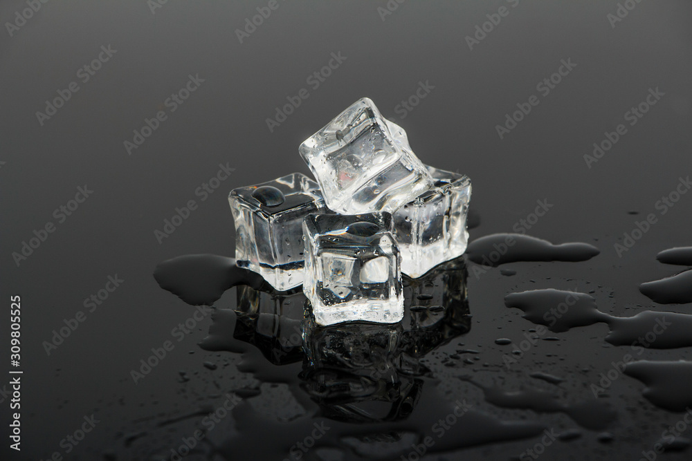 Ice cubes on a black reflective glass surface. Ice cubes on black glass. Ice cubes on a black reflective glass surface. Ice cubes on black glass.