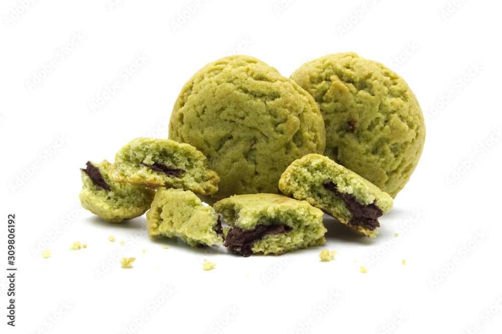 Fototapeta premium Crumbs of soft cookies green tea flavored filled with chocolate cream on white background.