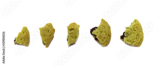 Crumbs of soft cookies green tea flavored filled with chocolate cream on white background.