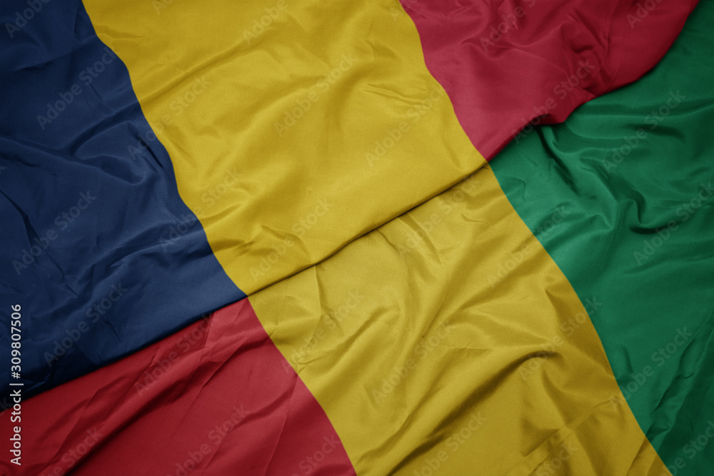 waving colorful flag of guinea and national flag of chad. waving colorful flag of guinea and national flag of chad.