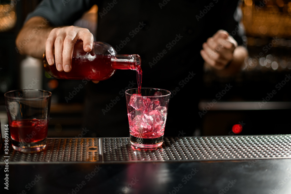 Bartender pouring liquor from bottle to glass