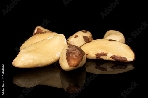 Group of seven whole brazil brown nut isolated on black glass