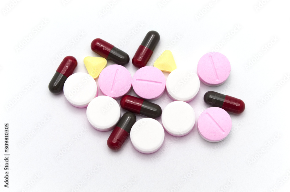 Prescription drugs, pills, capsules and tablets of different colors all mixed in. On white background. Prescription drugs, pills, capsules and tablets of different colors all mixed in. On white background.